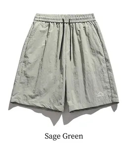 Detail of grey-green quick-dry shorts featuring elastic waist and mountain print logo