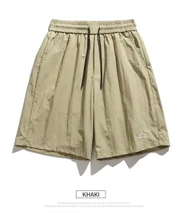 Detail of khaki quick-dry shorts featuring elastic waist and mountain embroidery