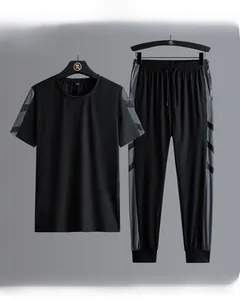 Detail of black sports set featuring grey diagonal stripes on sleeves and pants