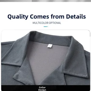 Detail of dark gray knit polo shirt showing ribbed texture and spread collar design