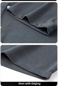 Detail of dark grey ribbed knit shirt showing the white button closure and edged hem