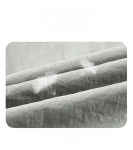 Detail view of water proof and windproof lightweight gray fabric with white duck down