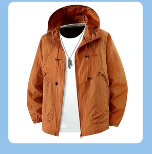 Detail of caramel windbreaker jacket showing thin fabric texture and drawstring hood