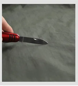 Gros plan sur le tissu extensible haute densité vert olive résistant aux rayures avec couteau