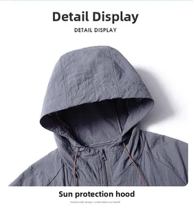 Detail view of grey sun protection jacket featuring a hood and orange drawstrings