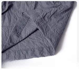 Detail view of the flat hem and double-row stitching on gray sun protection jacket