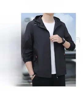 Détail de la veste pare-soleil noire avec capuche, lettrage outdoor et poches zippées