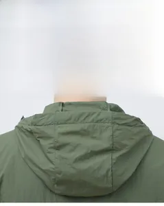 Vue détaillée de l'encolure à capuche et des coutures renforcées sur la veste solaire verte