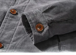 Close-up of grey corduroy jacket cuff featuring classic brown button and ribbed texture