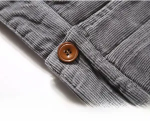 Macro shot of grey corduroy jacket hem featuring a premium brown four-hole button detail