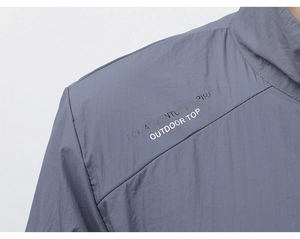 Detailed view of grey-blue sun protection jacket with printed adventure spirit slogan