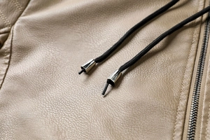 Détail de la veste en PU kaki avec texture en cuir de qualité et accents de zip métallique