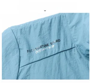 Détail de la veste d'extérieur bleu clair montrant le tissu ripstop et les imprimés