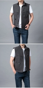 Detail view of the deep gray utility vest with multiple pockets and metal zipper closure