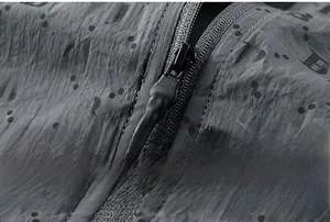 Detailed macro view of technical fabric featuring B monogram and high-quality corded zipper