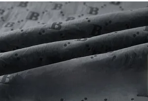 Detailed macro view of dark grey ice silk fabric with letter B monogram pattern