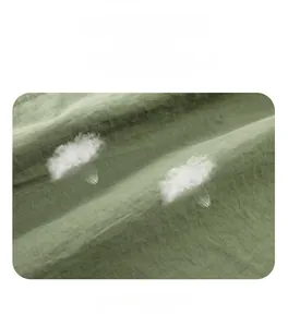 Detail of waterproof and windproof fabric with white duck down filling on olive green cargo shorts