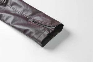 Détail du poignet d'une veste en cuir vintage avec fermeture éclair et texture grainée
