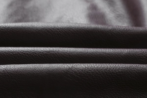 Gros plan de la texture grainée naturelle sur la veste vintage en cuir PU marron foncé