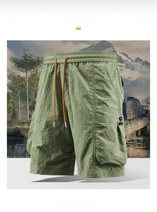 Detail of cargo shorts waist with orange drawstring and large flap pockets in bean green