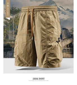 Detail view of khaki cargo shorts showing elastic waistband with orange drawstrings