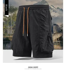 Detail of black cargo shorts featuring elastic waist with orange drawstring and large pockets