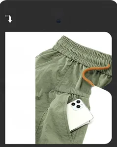 Detail of olive green cargo shorts featuring an elastic waistband and orange drawstring