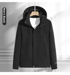 Détail d'une veste d'extérieur noire imperméable avec capuche et logo blanc au poignet