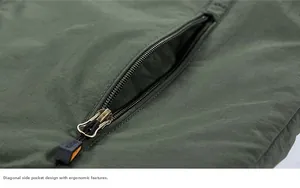 Detail of the diagonal side pocket with black metal zipper and sport puller on a green parka