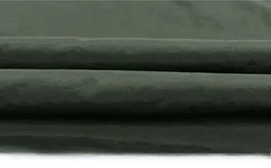 Macro shot of dark green fleece fabric detail showing smooth texture and high density