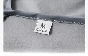 Macro shot of the collar label on a gray sun protection jacket with fine stitching detail