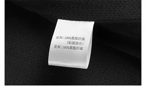 Detailed macro view of 100% polyester wash label on black mesh outdoor utility vest