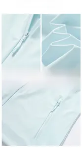 Detail view of smooth zipper, laser-cut air vents and thin hood fabric on sun protective jacket