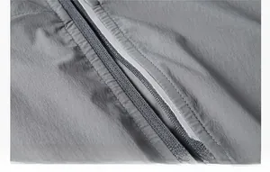 Detailed macro view of high-quality zipper and reflective strips on a gray sun protection jacket