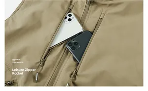 Détail du gilet outdoor kaki montrant une grande poche zippée verticale avec téléphone