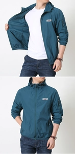 Detail view of men's blue windbreaker with mesh lining and elastic cuffs and hem