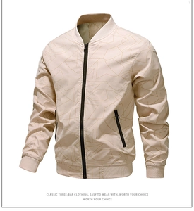 Detailed view of beige jacket with abstract print and black zip pockets on white background