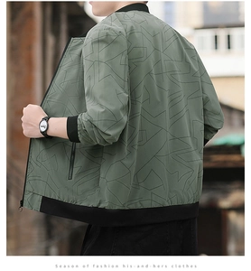 Detail of a men's sage green bomber jacket with black geometric prints and ribbed cuffs