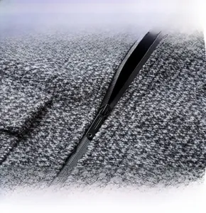 Détail de la fermeture éclair en métal et du tissu en laine texturé d'une veste grise