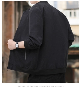 Close-up of black bomber jacket featuring geometric linear patterns and ribbed cuffs