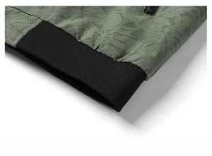 Détail de l'ourlet à imprimé feuilles vert militaire avec bords-côtes noirs élastiques