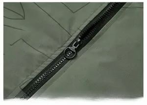 Detail of army green jacket featuring geometric patterns and a black metal MADE zipper