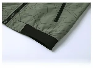 Detail of olive green jacket with elastic ribbed hem and black geometric print