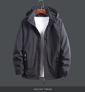 Detail of black hooded windbreaker jacket with adjustable cuffs and zipper chest pocket
