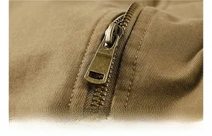 Detailed macro shot of a durable antique bronze metal zipper on khaki twill cotton jacket