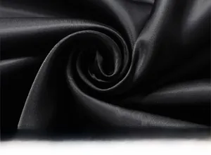Detailed view of high-gloss black satin fabric with elegant diagonal twill texture