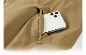 Detail of a functional side pocket on khaki cotton jacket holding a smartphone