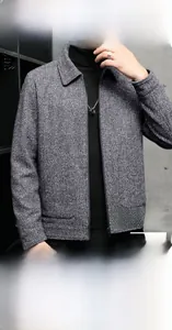 Close-up of gray wool blend jacket fabric showing fine herringbone texture and stitching
