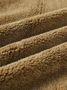 Close-up of premium caramel brown lamb wool fabric showing soft texture and thick lining