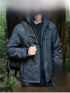 Detail of waterproof men's outdoor jacket showing detachable hood and camouflage texture